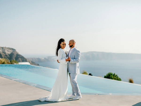Couple standing beside infinity pool at Eros Santorini