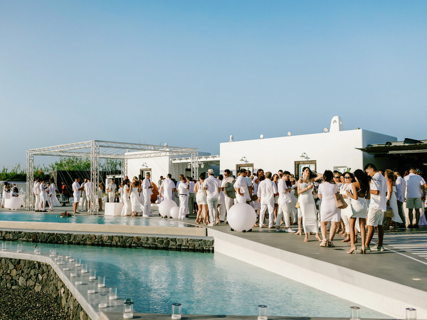 Guests gathering around pool at Santorini destination wedding event