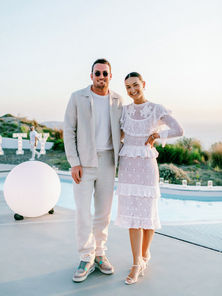 Couple portrait at sunset overlooking Santorini cliffs