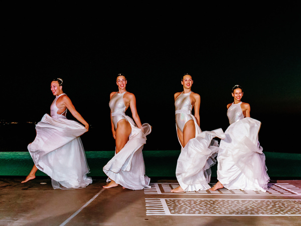 Synchronized swimmers performing at Santorini wedding welcome party