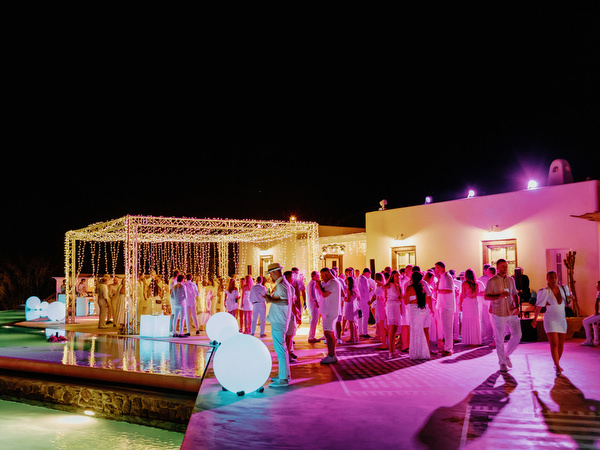 Guests dancing in pool during Santorini wedding welcome party