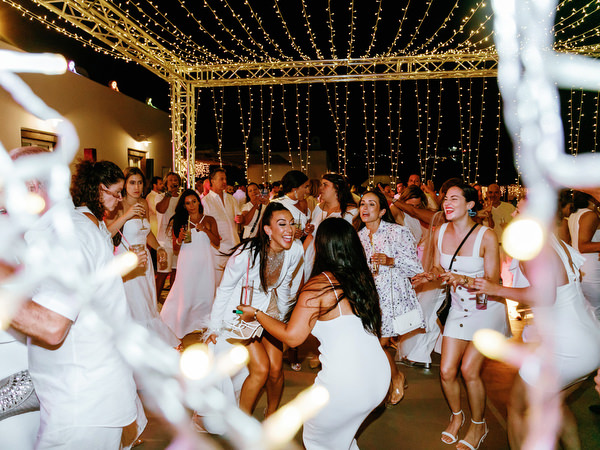 Guests dancing under lights during Santorini wedding celebration