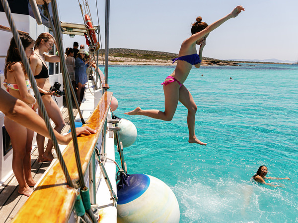 Guest jumping into turquoise sea during Antiparos pre-wedding boat cruise