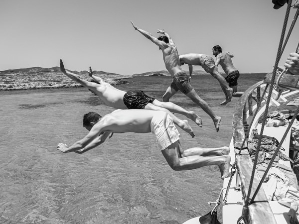 Guests diving from sailboat during Antiparos pre-wedding boat cruise