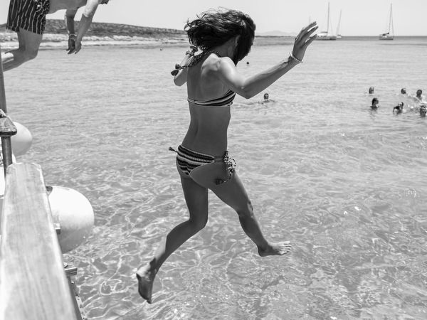 Woman jumping into sea during Antiparos pre-wedding boat cruise