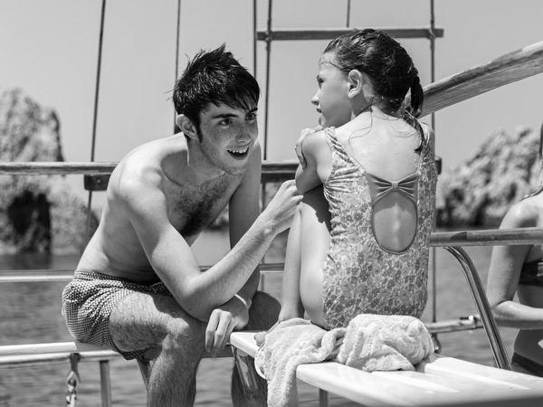 Kids sharing playful moment during Antiparos pre-wedding boat cruise