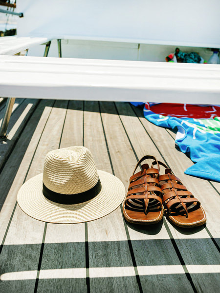 Hat and beach essentials on sailboat during Antiparos cruise