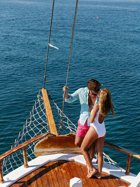 Couple kissing on sailboat bow during Antiparos pre-wedding cruise