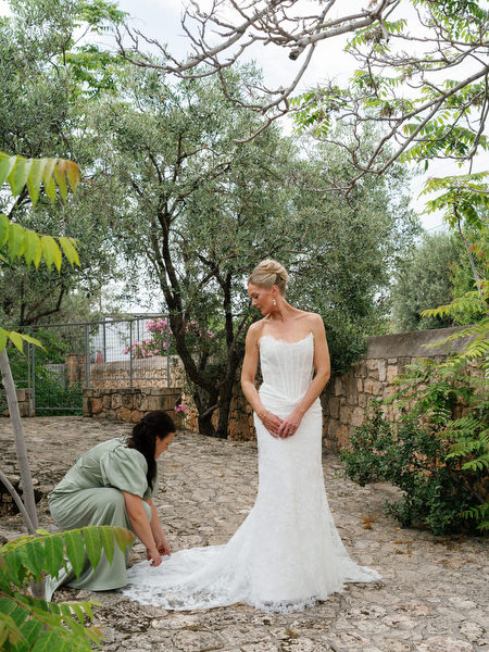 Bride getting help with her wedding dress during morning preparations in Aegina