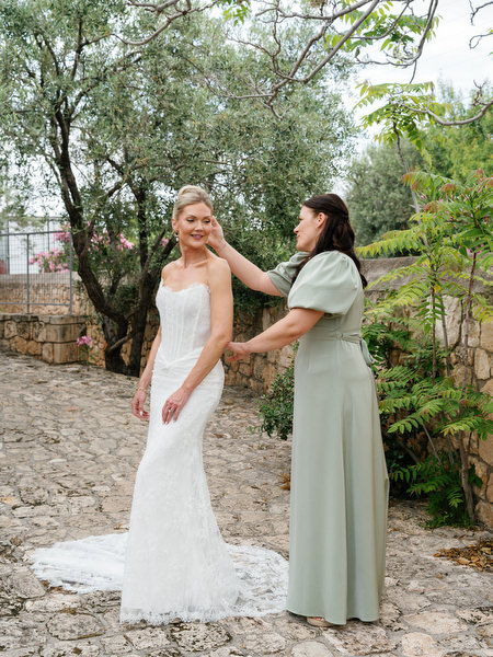 Bride and bridesmaid during relaxed wedding preparations on Aegina island