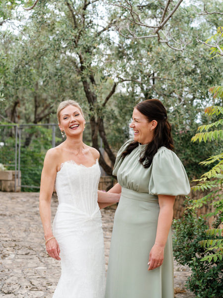 Bride smiling with her bridesmaid during preparations for her Aegina wedding