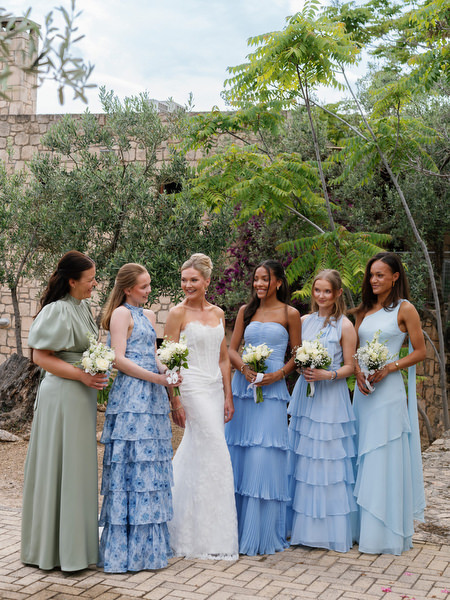 Bride and bridesmaids posing together in a Mediterranean garden on Aegina island