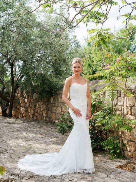 Full-length bridal portrait in an elegant wedding gown in a Greek island garden