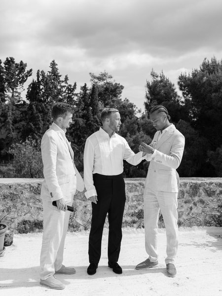 Black and white candid moment with the groom and groomsmen during wedding preparations