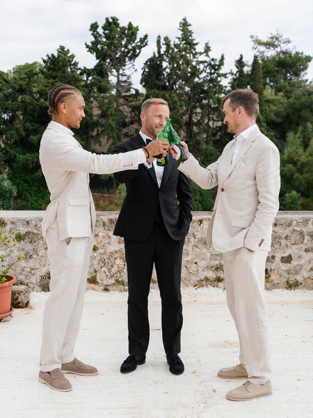 Groomsmen adjusting the groom’s tuxedo before the Pyrgos Ralli ceremony