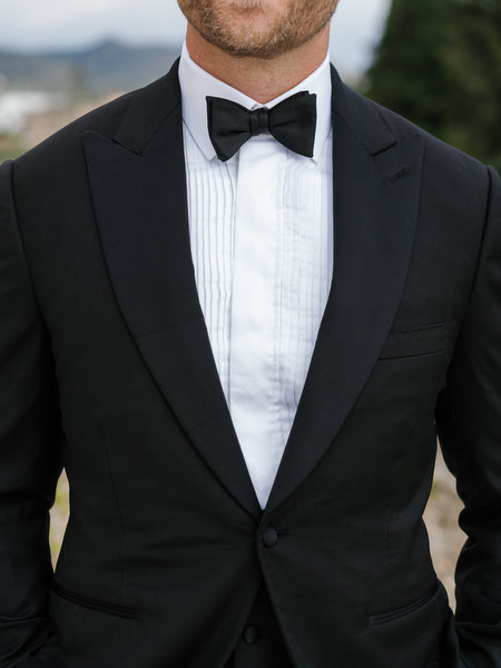 Close-up portrait of the groom in an elegant black tuxedo and bow tie