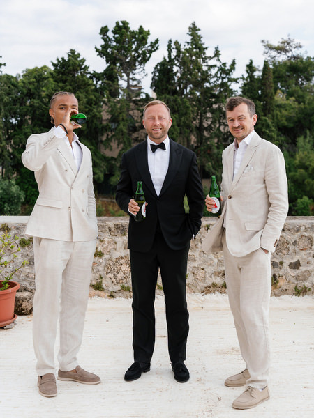 Groom and groomsmen posing together during an elegant destination wedding in Aegina