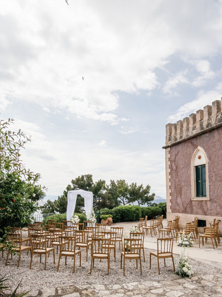 Outdoor wedding ceremony setup beside the historic tower at Pyrgos Ralli