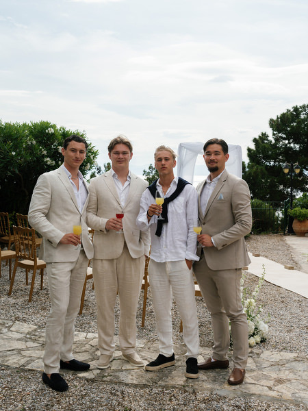Groomsmen posing together before the outdoor ceremony at Pyrgos Ralli in Aegina