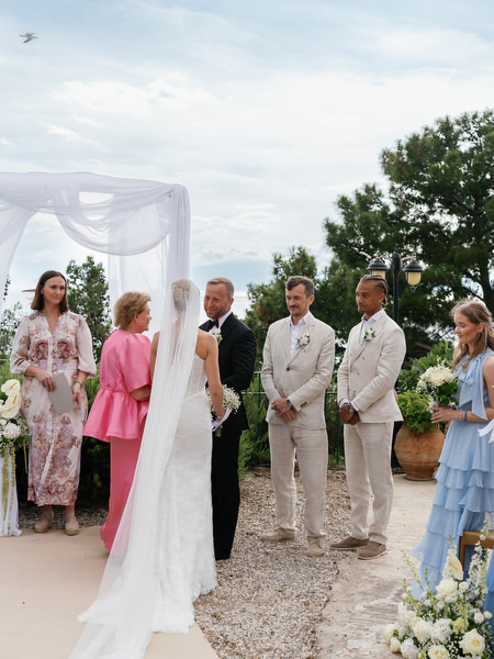 Bride arriving at the altar as guests watch during the Pyrgos Ralli wedding ceremony