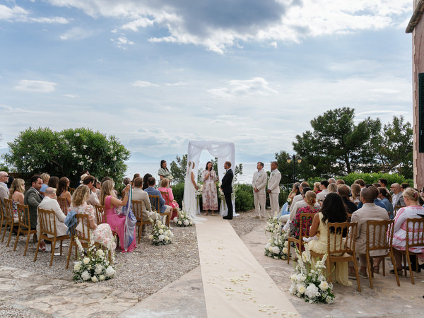 Guests seated beneath the Greek summer sky during a destination wedding in Aegina
