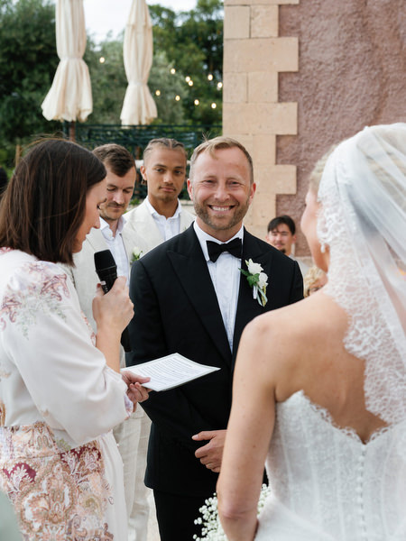 Groom reading vows during an emotional outdoor wedding ceremony at Pyrgos Ralli