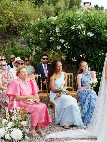 Wedding guests smiling during Anne and Peter’s ceremony in Aegina