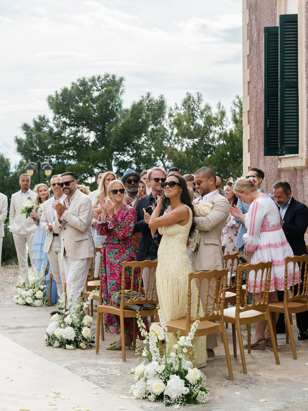 Guests celebrating Anne and Peter as they exit their Aegina wedding ceremony