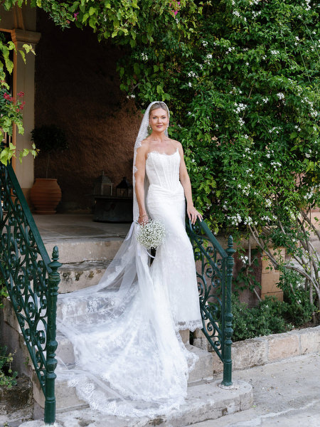 Bride standing beside an ivy-covered entrance during wedding portraits at Pyrgos Ralli