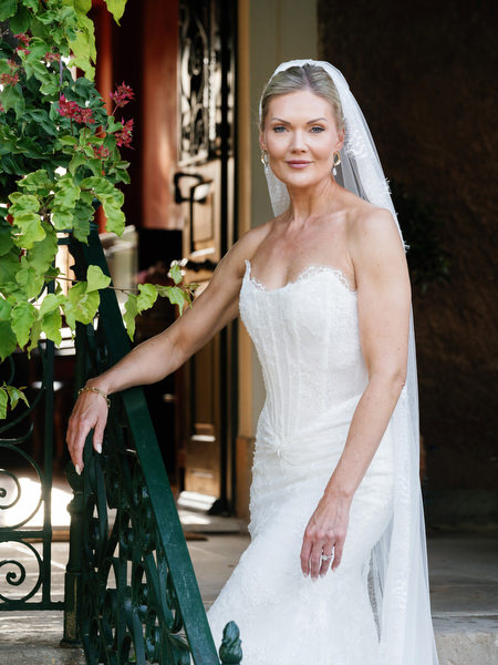 Elegant bridal portrait beside a green railing and ivy-covered doorway at Pyrgos Ralli