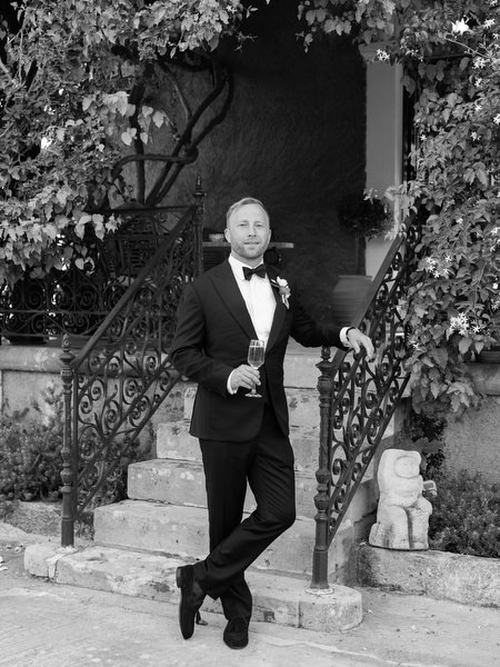 Black and white groom portrait on the historic steps at Pyrgos Ralli in Aegina