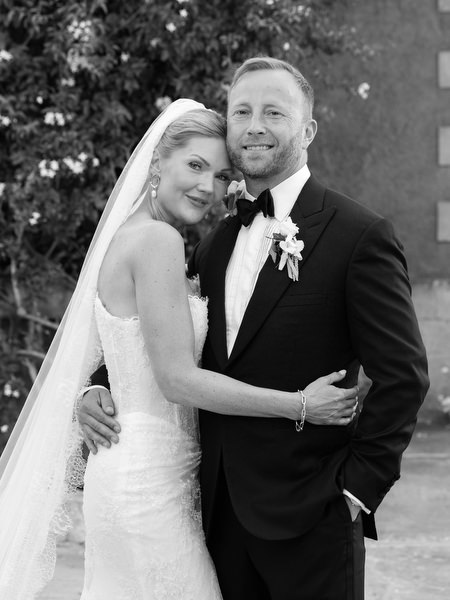 Black and white portrait of the bride and groom embracing after their wedding ceremony