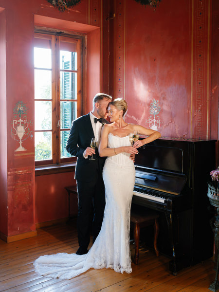 Bride and groom posing in the dramatic red interior of Pyrgos Ralli in Aegina