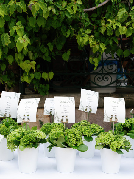 Wedding escort cards displayed beneath lush greenery at Pyrgos Ralli in Aegina