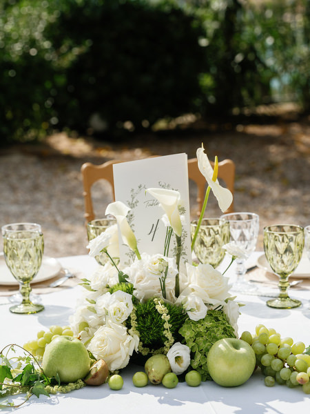 Close-up of elegant wedding table flowers and glassware at the outdoor reception