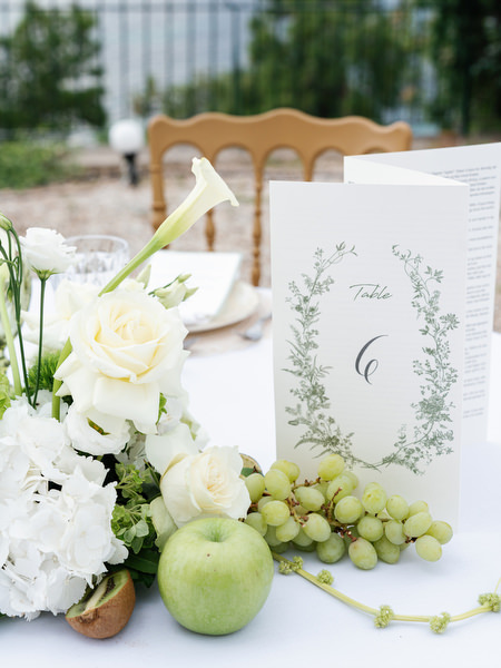Wedding menu and place setting with white flowers and green grapes at Pyrgos Ralli