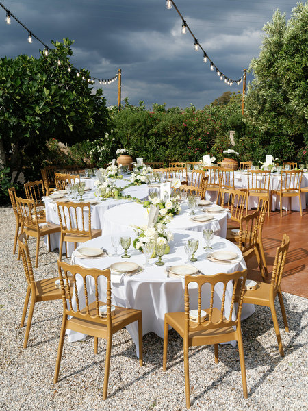 Wide view of the outdoor wedding reception beneath string lights in Aegina