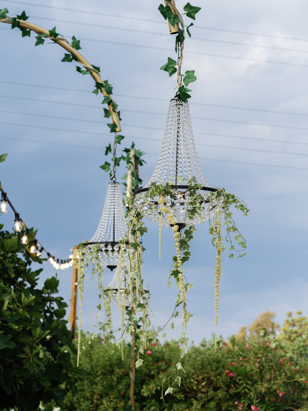 Decorated arch and string lights overlooking the sea at a Pyrgos Ralli wedding