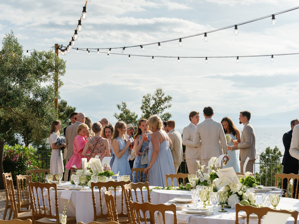 Wedding guests gathering for dinner with the Saronic Gulf in the background