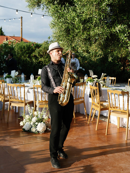 Saxophone musician performing during the outdoor wedding reception at Pyrgos Ralli