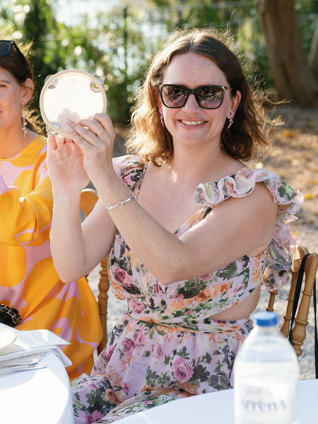 Wedding guest smiling in sunglasses during the outdoor celebration in Aegina