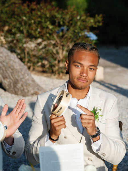 Wedding guest enjoying a drink during the elegant outdoor reception in Aegina