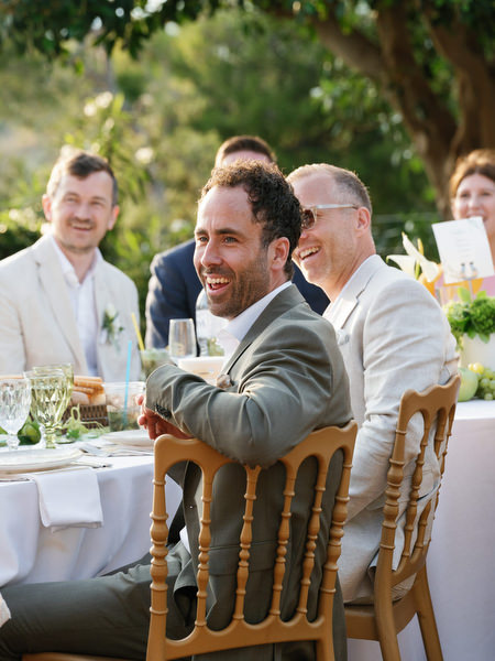 Wedding guest laughing during dinner at the outdoor Pyrgos Ralli reception