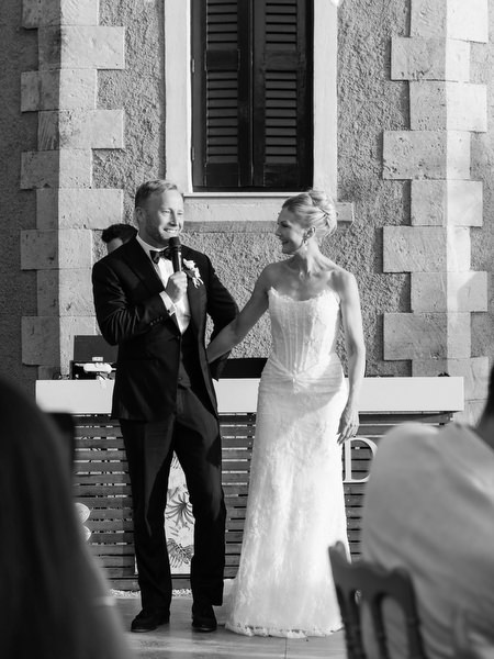 Black and white portrait of the newlyweds beside the historic stone architecture of Pyrgos Ralli
