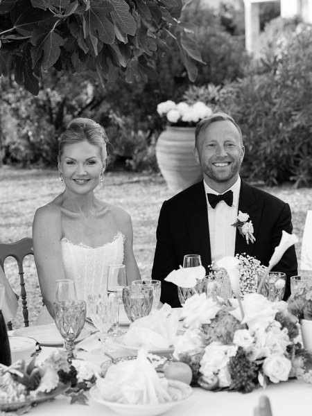 Black and white candid of the bride and groom seated together during wedding dinner