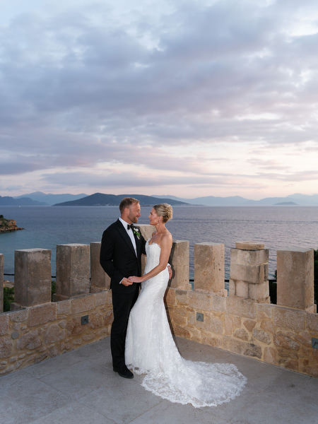 Newlyweds standing together on the terrace during their Aegina wedding portraits