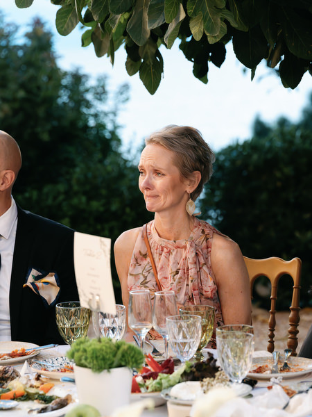 Wedding guest smiling during the candlelit outdoor dinner at Pyrgos Ralli