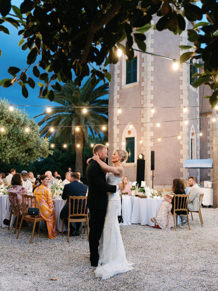 Bride standing beside the illuminated Pyrgos Ralli tower during the reception