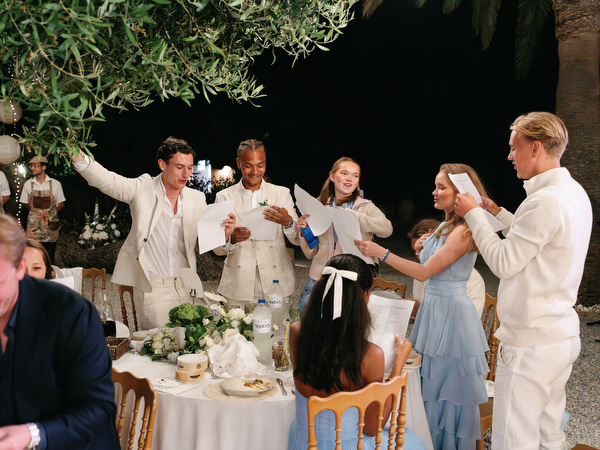Wedding guests raising their glasses during a lively evening reception at Pyrgos Ralli