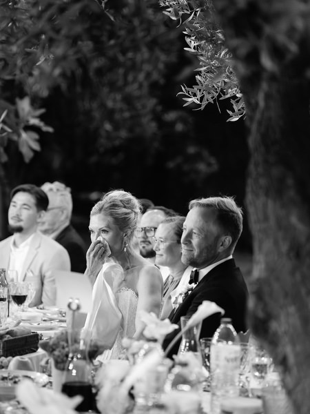 Black and white candid of the bride and groom reacting during wedding speeches